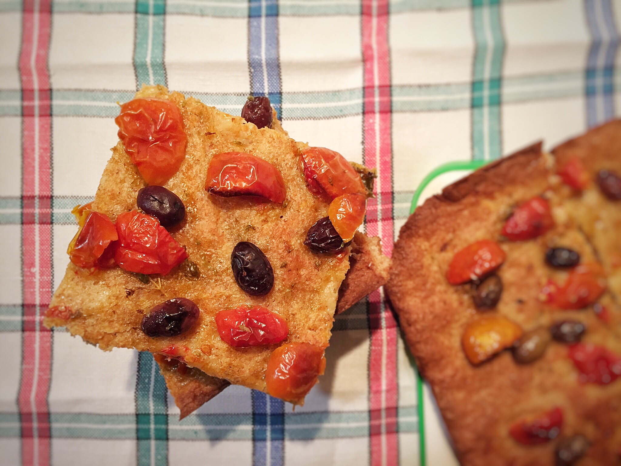 Quadrotti di focaccia integrale con pomodorini e olive taggiasche